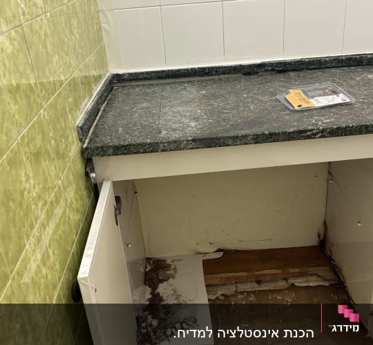 ארון מטבח פתוח עם סימני רטיבות ועובש
